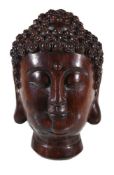 A Chinese wood Buddha head, possibly aloeswood, the head with carved tight curls, 25.5cm high, 1,482
