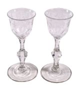 A pair of engraved facet stemmed wine glasses, late 18th century, the ogee bowls with everted rims