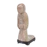 A Chinese archaistic style celadon and grey jade figure, depicted kneeling in flowing robes, incised