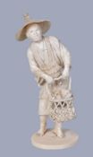 Y A Japanese Ivory Okimono carved as a standing fisherman wearing a reed apron and a broad straw hat