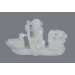 A Chinese white jade ‘boat and goose’ carving, depicting a kneeling boy with paddle and goose and