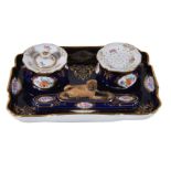 A Meissen porcelain blue-ground inkwell and accoutrements, late 19th century, painted with panels of