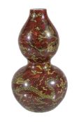 A Chinese double gourd 'dragon' vase, with yellow and black dragons on a red-brown ground, with