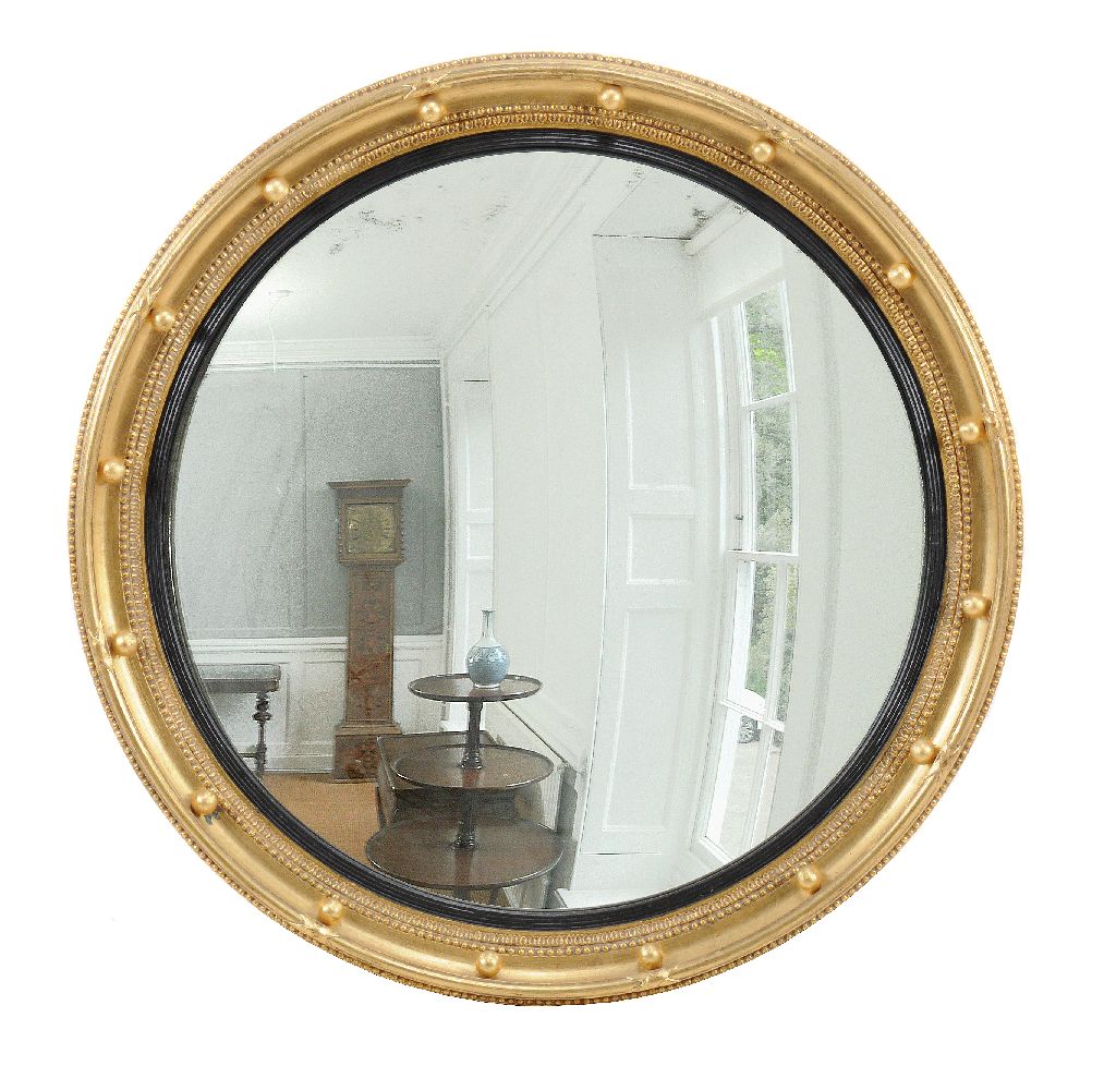 A giltwood convex wall mirror in Regency style, 20th century, 90cm diameter Provenance: Property