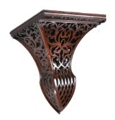 A Victorian carved and stained walnut wall bracket, circa 1860, the rectangular top above a