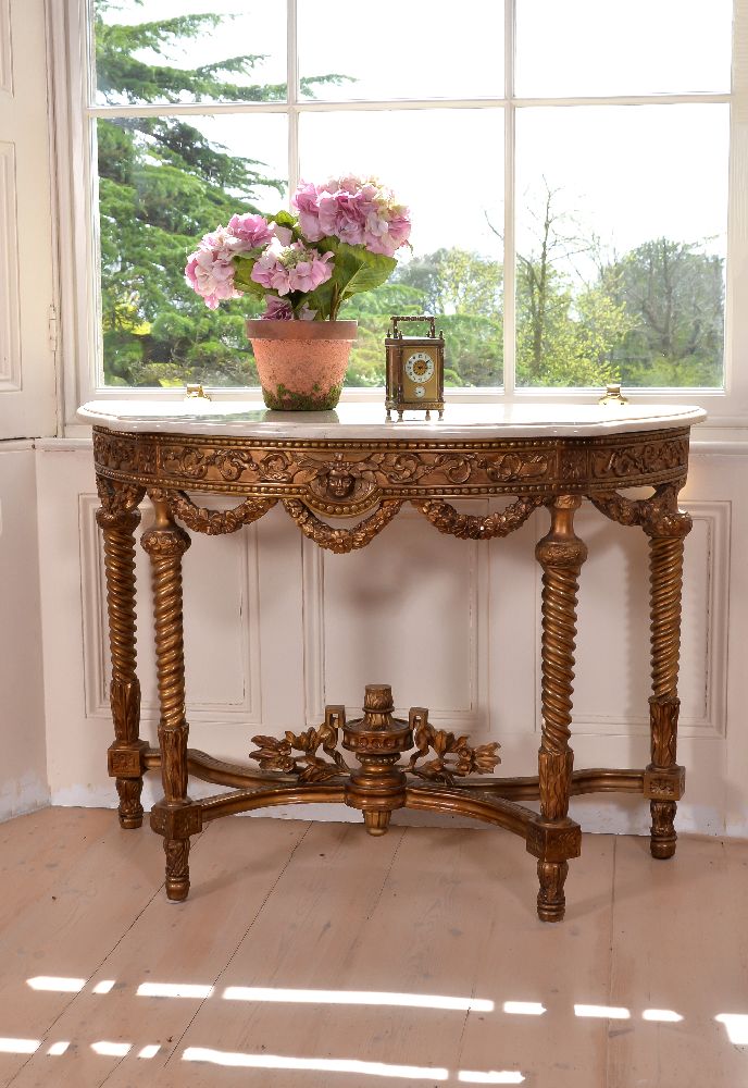 A carved giltwood and marble topped console table, late 19th century, of semi-elliptical outline,