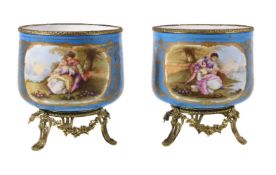 A pair of Sevres-style porcelain gilt-metal mounted jardinieres, circa 1900, painted with panels