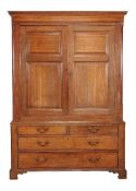 A George III oak press cupboard, circa 1770, the panel doors enclosing a hanging compartment flanked