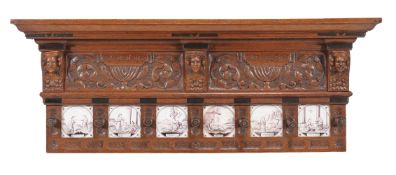 A carved oak coat rack, 20th century, probably Dutch, with six puce biblical tiles interspersing the