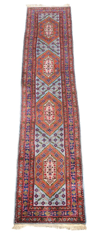 A Hamadan runner, decorated with lozenge medallions in tones of burnt orange, sky blue and