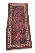 A Hamadan runner, decorated with cruciform medallions, in tones of red, blues, and cream,