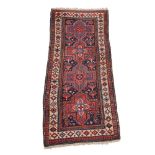 A Hamadan runner, decorated with cruciform medallions, in tones of red, blues, and cream,