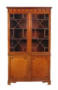 A mahogany banded and inlaid bookcase cabinet, 19th century, the glazed doors enclosing adjustable