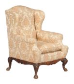 A mahogany and floral upholstered wing armchair in George III style, early 20th century, the