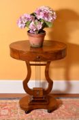 A walnut oval occasional table in Empire style, late 19th century, the quarter veneered top above