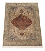 A woven carpet in Kashan style, the pale field decorated profusely with polychrome floral and