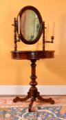 A mahogany dressing stand, mid-19th century, the oval mirror on turned sconce supports above the