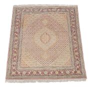 A Tabriz rug, the pale pink field decorated by a medallion and cornered by spandrels, within a