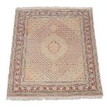 A Tabriz rug, the pale pink field decorated by a medallion and cornered by spandrels, within a