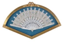 A Regency bone fan, decorated with fronds and sprays, in a giltwood and glazed display case, the fan