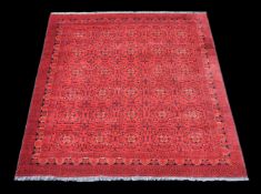 A Bokhara carpet, of overall design, the madder field decorated with foliate and geometric motifs in