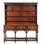 An oak high dresser, late 18th century, the base with three frieze drawers, above a slatted