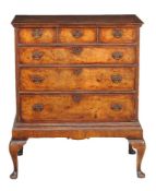 A walnut and feather banded chest on stand in George II style, late 19th/early 20th century, 124cm