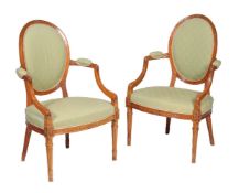 A pair of solid satinwood open armchairs in George III style, circa 1900, after the manner of John