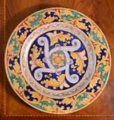 A modern Italian Maiolica charger, typically decorated with foliate arabesques in shades of red,