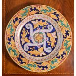 A modern Italian Maiolica charger, typically decorated with foliate arabesques in shades of red,