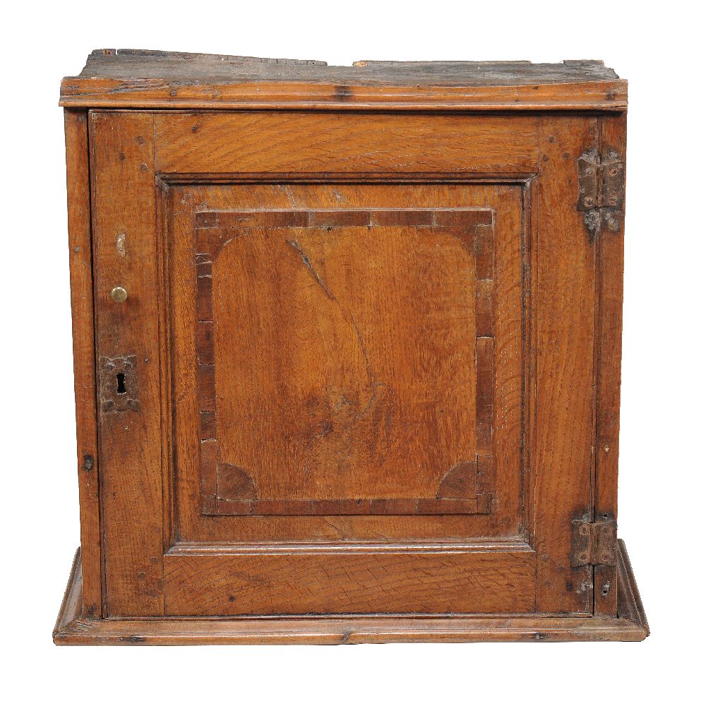 An oak and mahogany banded spice cupboard, mid 18th century, the panel door enclosing an arrangement