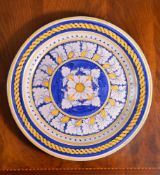 A modern Italian Maiolica charger, decorated in shades of blue and ochre, with a central flower head