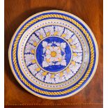 A modern Italian Maiolica charger, decorated in shades of blue and ochre, with a central flower head