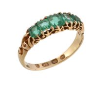 A Victorian 18 carat gold emerald ring, set with graduating square cut emeralds, within a pierced