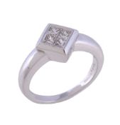 A diamond ring, the square panel set with four square cut diamonds, approximately 0.25 carats total,