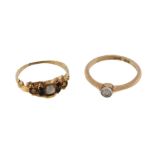 A late 19th century half pearl ring, set with three half pearls and circular cut black stones,