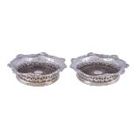 A pair of Edwardian silver shaped circular coasters, one marked George Fox, London 1902, the other