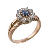 A sapphire and diamond cluster ring, the central circular cut sapphire claw set within a surround of