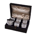 A cased set of six silver shaped circular napkin rings by Josiah Williams & Co., London 1921, chased