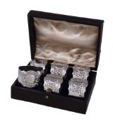 A cased set of six silver shaped circular napkin rings by Josiah Williams & Co., London 1921, chased