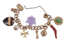 A gold coloured charm bracelet, the curb link bracelet with various charms, including a heart shaped