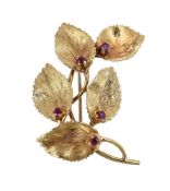 A 1970s 18 carat gold and ruby leaf brooch, the textured leaves each set with a circular cut ruby,