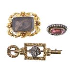 A Victorian hairwork brooch, the rectangular glazed panel with plaited hair beneath, within a