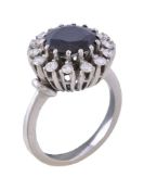 A 1970s sapphire and diamond cluster ring, the central circular cut sapphire claw set within a