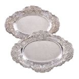 A pair of Edwardian silver pierced and embossed shaped oval baskets by Harrison Brothers & Howson,