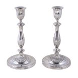 A pair of English circular candlesticks, apparently unmarked, circa 1790, with part fluted capitals,
