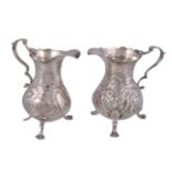 Two mid Georgian silver baluster cream jugs, the first by John Muns, London 1767, with a leaf-capped