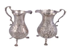 Two mid Georgian silver baluster cream jugs, the first by John Muns, London 1767, with a leaf-capped