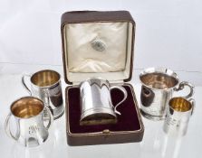 Five silver christening mugs, to include: a cased slightly tapering mug by Goldsmiths & Silversmiths