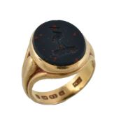 A Victorian 18 carat gold bloodstone signet ring, the oval bloodstone panel carved with a crest,